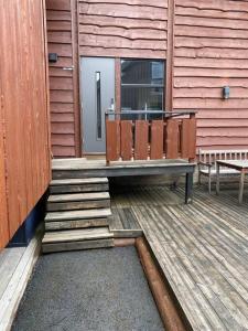 a wooden deck with a bench on a building at Very centrally located apartment with free parking in Tromsø
