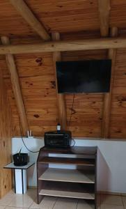 Habitación con TV en el techo y paredes de madera. en Alpes San Rafael en San Rafael