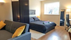 a living room with a bed and a couch at Modern 1-Bed Flat in Wigan in Wigan