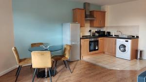 威根的住宿－Modern 1-Bed Flat in Wigan，厨房配有桌子、洗衣机和烘干机