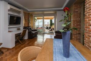 a living room with a table and a vase with a plant at Villa Alenor Nessebar in Nesebar