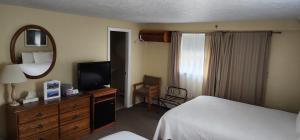 a hotel room with a bed and a television at Wilson Lake Inn in Wilton
