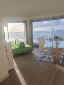 a living room with a table and a couch and windows at Le Splendid in La Baule