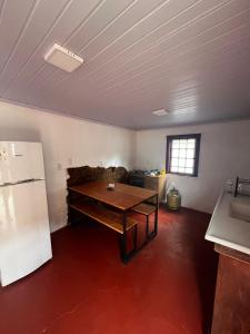 a living room with a table and a refrigerator at Casa do Chafariz Tiradentes in Tiradentes