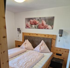 um quarto com uma cama com flores cor-de-rosa na parede em Gern Mountain Living Ferienhaus Deutschmann em Sankt Johann im Pongau