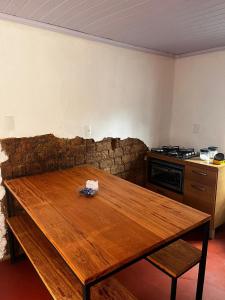a wooden table in a room with a kitchen at Casa do Chafariz Tiradentes in Tiradentes