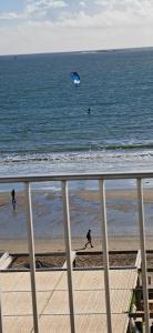 two people on the beach with a kite in the ocean at Le Splendid in La Baule