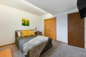 a bedroom with a bed and a wooden door at Cedar Rapids Vacation Rental 2 Mi to Downtown! in Cedar Rapids