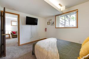 een slaapkamer met een bed en een flatscreen-tv bij Cedar Rapids Vacation Rental 2 Mi to Downtown! in Cedar Rapids