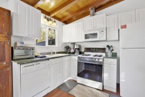 uma cozinha branca com armários brancos e electrodomésticos brancos em 2004- Vogel Haus home em Big Bear Lake