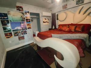 um quarto com uma cama com uma cadeira branca em Downtown Chop Shop house, HUGE garage pets allowed em Fort Smith