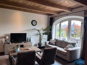 a living room with a couch and a tv at Vakantiewoning 't Veldzicht in Rossum