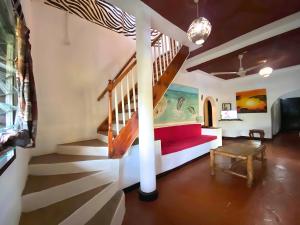 a living room with a red couch and stairs at Villas Dora and Holly in Diani Beach