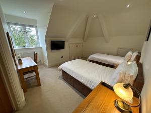 a bedroom with two beds and a table with a table at Meadows Barn in Chelmsford