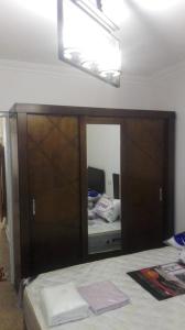 een spiegel aan een muur in een kamer met een bed bij Cozy fully well furnished apartment for rent in Mesaha Square - Dooki in Caïro