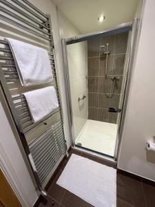 a bathroom with a shower with white towels on it at Meadows Barn in Chelmsford