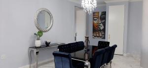 4 on Pritchard Luxury Suites في جوهانسبرغ: غرفة طعام مع طاولة وكراسي ومرآة