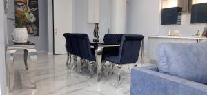 ein Esszimmer mit einem Tisch und blauen Stühlen in der Unterkunft 4 on Pritchard Luxury Suites in Johannesburg