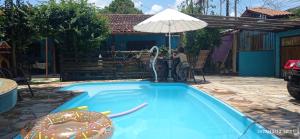 a pool with an inflatable donut and an umbrella at Espaço Dona Florinha in Ilhabela