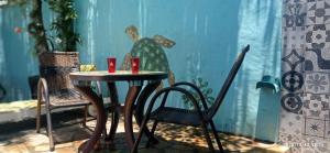 a table and chairs in front of a blue wall at Espaço Dona Florinha in Ilhabela