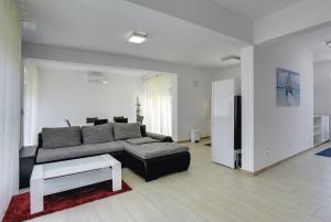 uma sala de estar com um sofá e uma mesa em Villa Lara I em Ližnjan