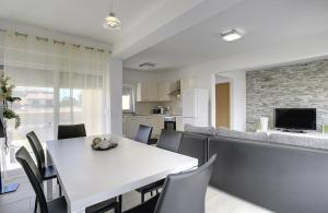 uma sala de jantar e cozinha com uma mesa branca e cadeiras em Villa Lara I em Ližnjan
