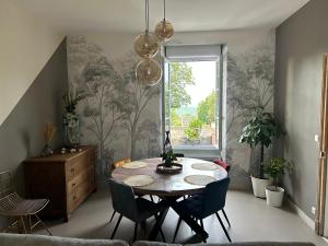 d'une salle à manger avec une table, des chaises et une fenêtre. dans l'établissement Part des Anges - Gîte Hautvillers, à Hautvillers