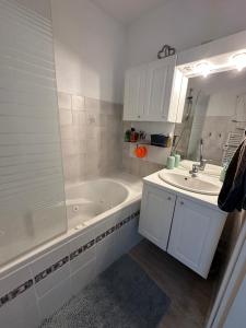 Un baño blanco con bañera y lavabo. en toproom2, en Estrasburgo