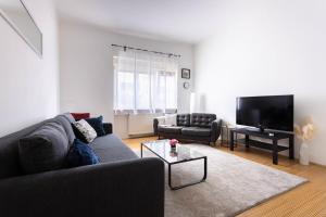a living room with a couch and a tv at Apartment Ana By Blue Apartments in Zagreb