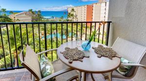 a table and chairs on a balcony with a view of the ocean at Maui Westside Presents: Kaanapali Shores 733 Stunning Ocean Views NEW LISTING in Lahaina