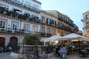 a group of tables and umbrellas in front of a building at A' Nica room in Palermo