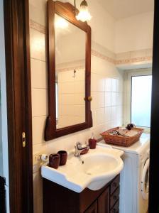 een badkamer met een wastafel, een spiegel en een wasmachine bij Vicolo Savelli Holiday Home in Palombara Sabina