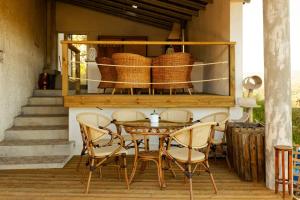 - une table et des chaises sur une terrasse couverte avec des paniers dans l'établissement Quinta Refúgios do Rio Dão, à Mangualde