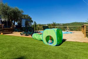 a playground with a slide in the grass at Quinta Refúgios do Rio Dão in Mangualde