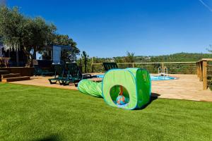 un parque infantil con un tobogán en el césped en Quinta Refúgios do Rio Dão, en Mangualde