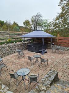 a patio with tables and chairs and an umbrella at Csipke Vendégház in Orfű