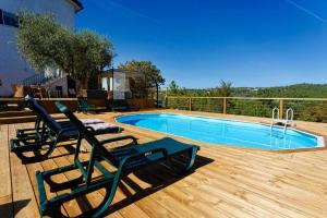 - une piscine avec 2 chaises longues à côté d'une terrasse dans l'établissement Quinta Refúgios do Rio Dão, à Mangualde