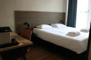 a hotel room with a bed with two towels on it at Hotel Mosaic City Centre in Amsterdam