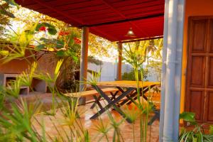VILLA TIARÉ DIEGO في Antsakomboena: طاولة نزهة تحت مظلة حمراء على الفناء