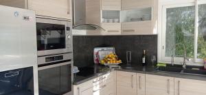 a kitchen with a bowl of fruit on the counter at Maison au calme avec jardin et piscine Saint Raphaël in Saint-Raphaël
