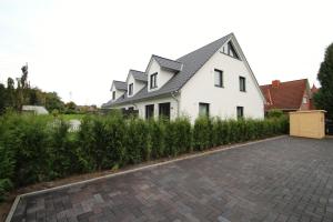 a white house with a brick driveway at Sunseeker House 2 in Bad Schwartau