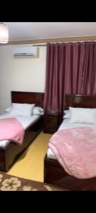 ein Schlafzimmer mit 2 Betten und einem roten Vorhang in der Unterkunft عباس العقاد in Kairo