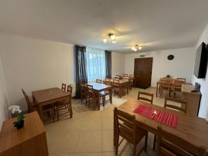 a dining room with wooden tables and chairs at Cassa-Grande in Bozovici