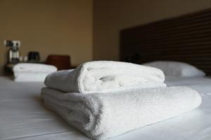 a pile of towels sitting on top of a bed at Hotel Mosaic City Centre in Amsterdam