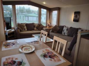 een keuken en een woonkamer met een tafel en een bank bij Ann & Rogers Retreat Skipsea Sands in Ulrome