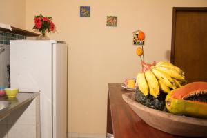 a kitchen with a bowl of bananas and a refrigerator at Trindade Hospeda - Casinha Praia Ranchos in Trindade