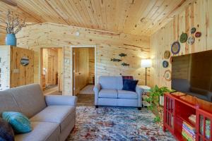 a living room with a couch and a tv at Lakefront Paradise with Private Boat Dock and Patio in Deer River