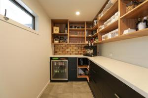 a kitchen with black cabinets and a counter top at Airport Oasis in Rotorua