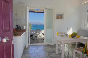 una cucina con porta che si apre su un patio con tavolo di Playera bungalow F sea view a Kolympithres