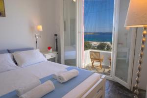 a bedroom with a bed and a balcony with the ocean at Playera bungalow F sea view in Kolympithres